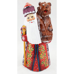New Year and Christmas carved wooden toy Santa Claus with a bear on his shoulder